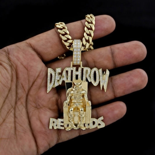 Gold Death Row Records pendant with diamond-set lettering and detailed electric chair figure on Cuban link chain, shown in hand against black background.